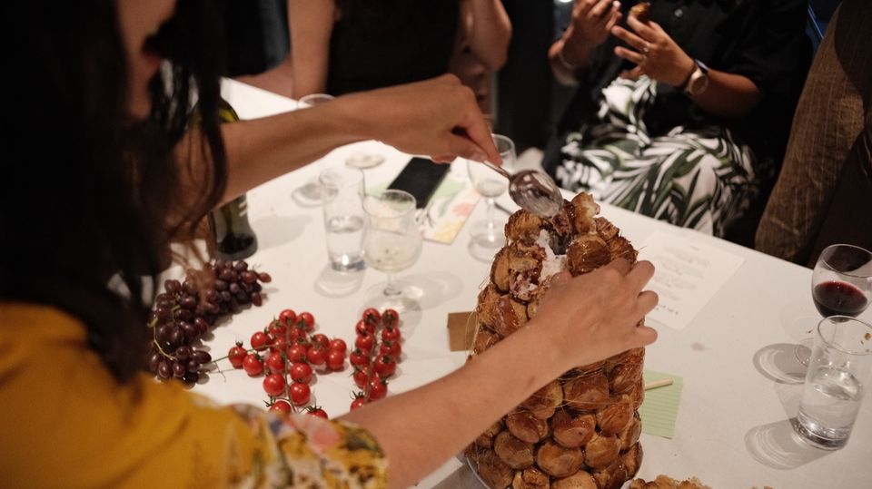 Guests sharing a tower of pastries at the supper table